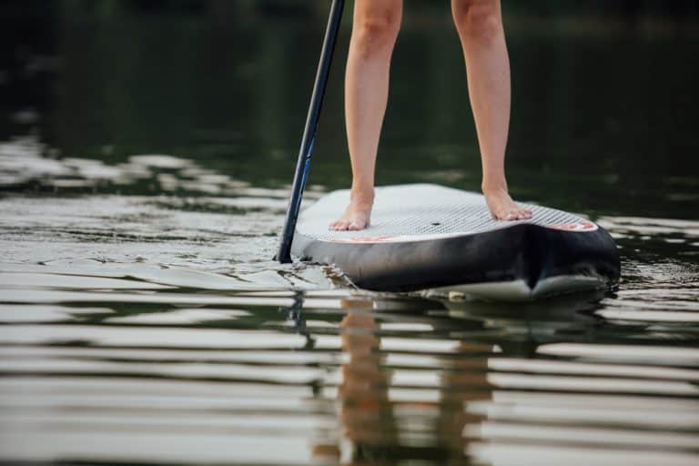 clouse-up of a woman legs on paddleboard