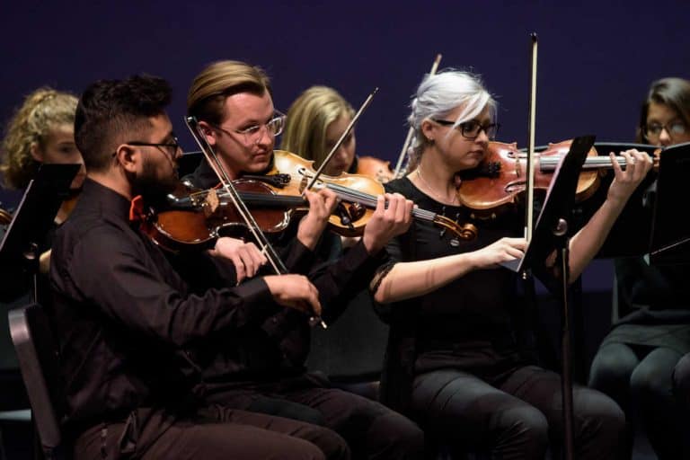 Friends University Sinfonietta violinists playing