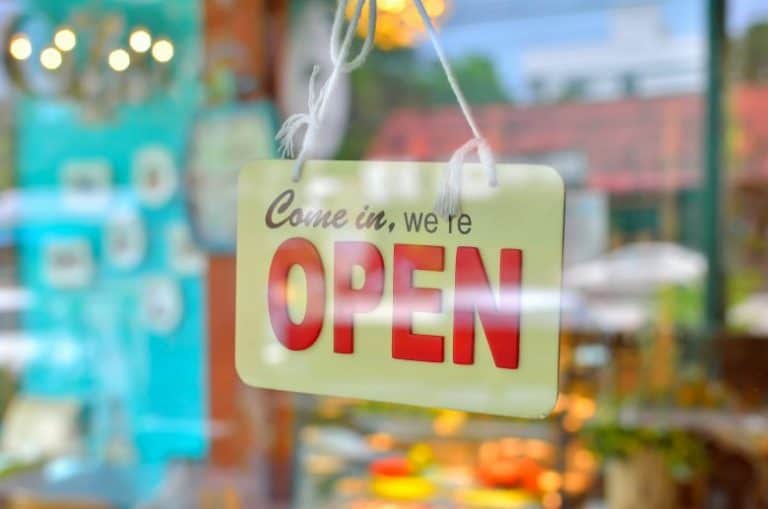 Small local business sign on door says "Come in, we're open"