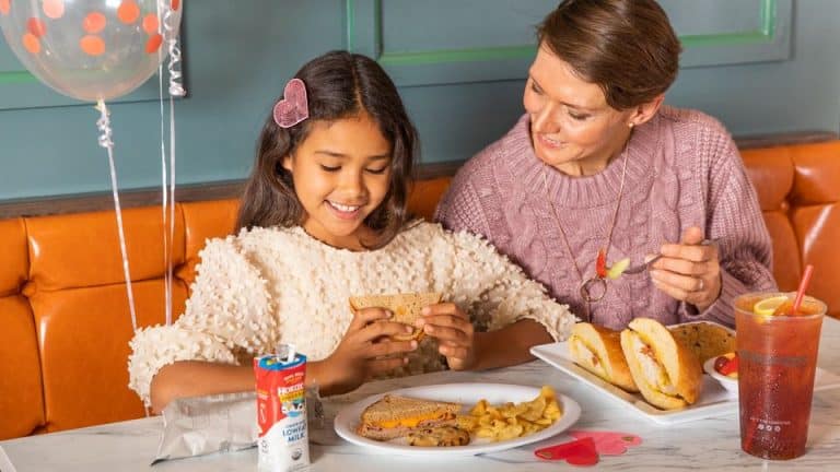 Child enjoying free meal at mcalister's deli on valentines day with adult mom sitting near
