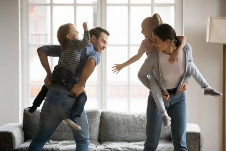 parents carrying kids piggyback playing game together